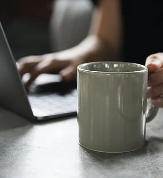 Getränkebecher und ein Laptop